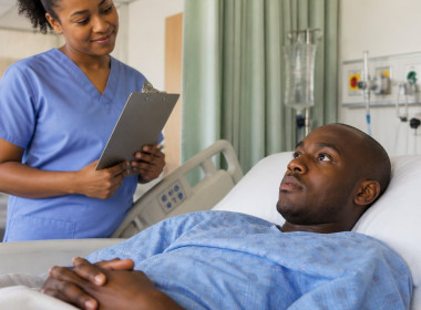Patient awake in hospital recovery bed with nurse nearby, concerned expressions.