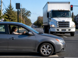 Moment before a delivery truck T-bones a car at an intersection