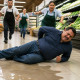 Man lying on wet grocery store floor in pain with employees rushing to help